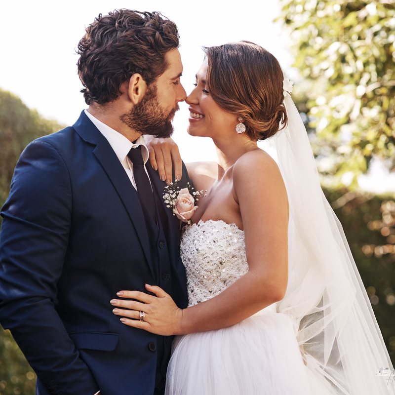 Bride and groom sharing a quiet forehead-to-forehead moment outdoors
