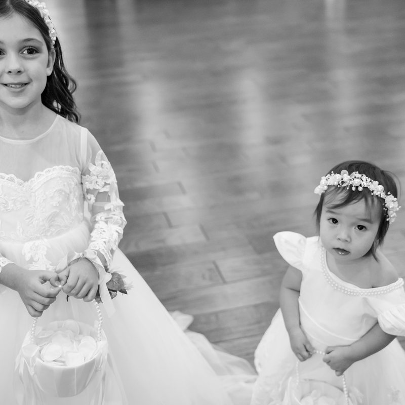 Black-and-white portrait of two flower girls in white dresses