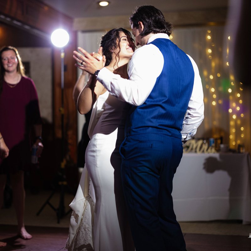 Couple sharing their first dance under string lights at the reception
