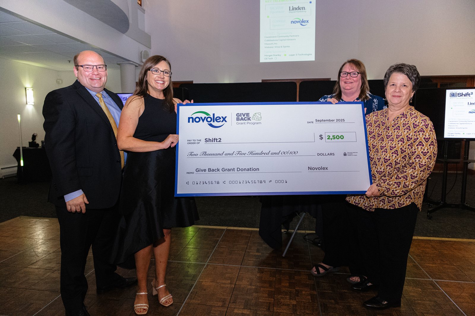 Oversized donation check presentation at the Shift 2 Key Celebration