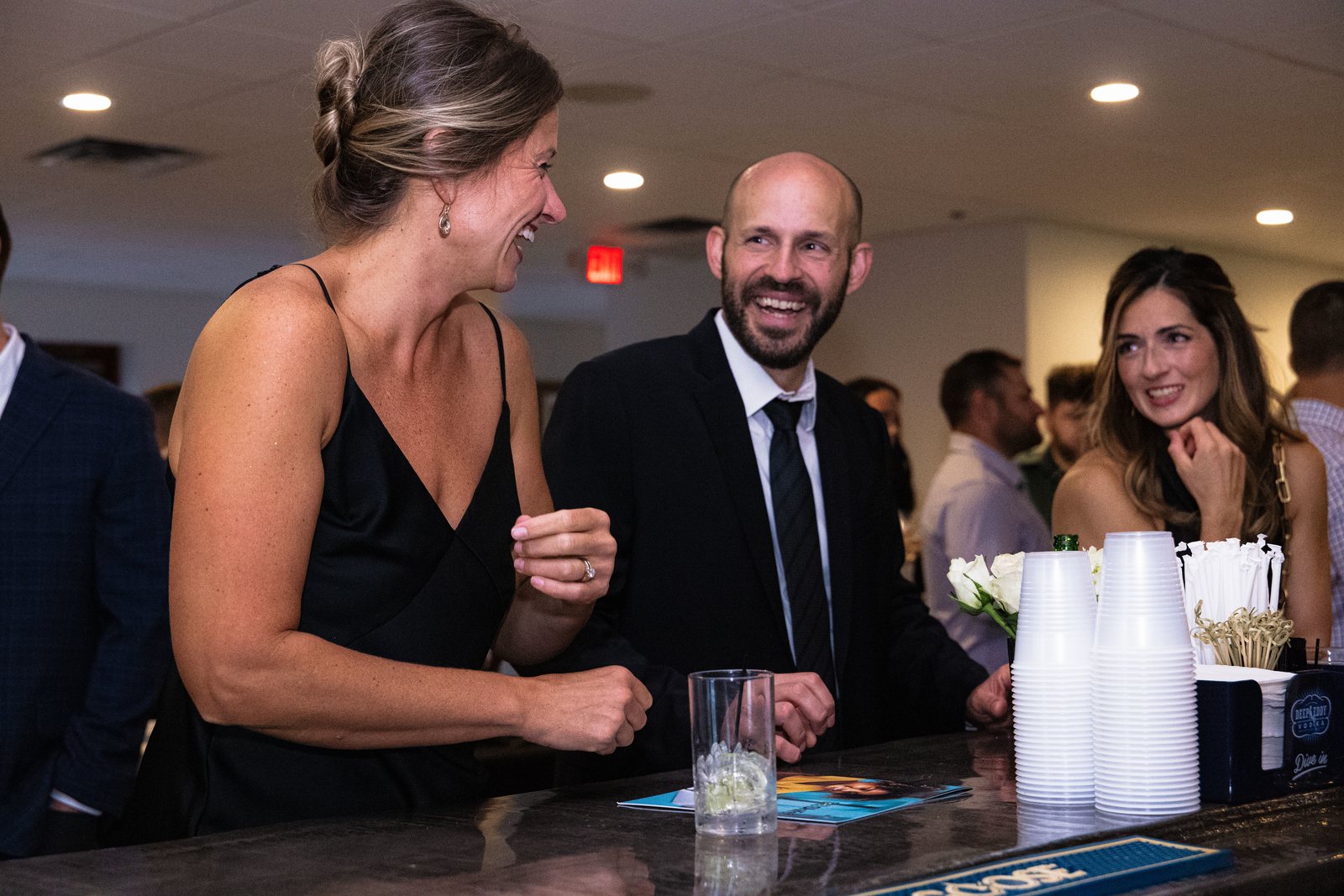 Guests smiling and chatting at the bar during a cocktail reception