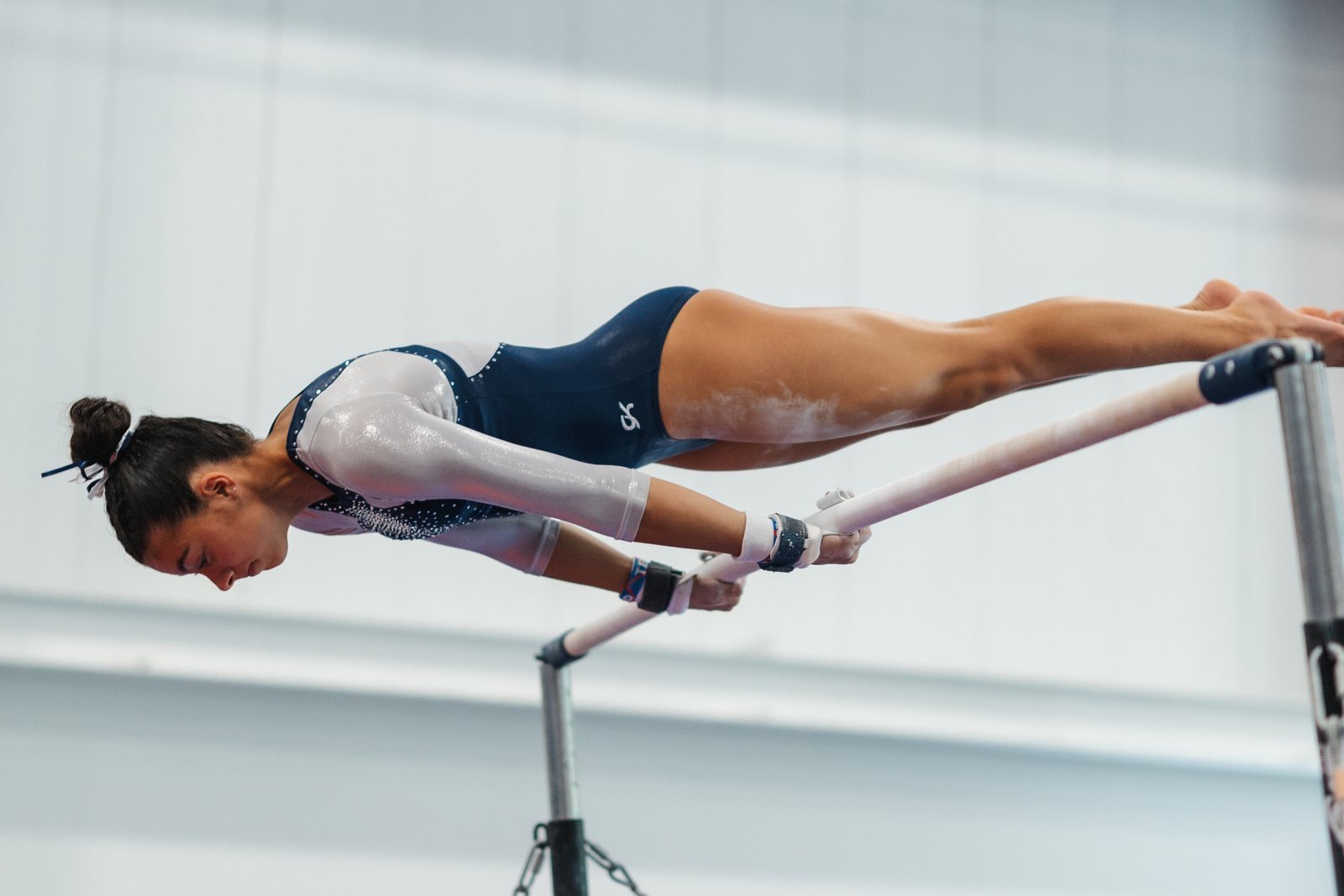 Gymnast stretched fully horizontal over the uneven bars