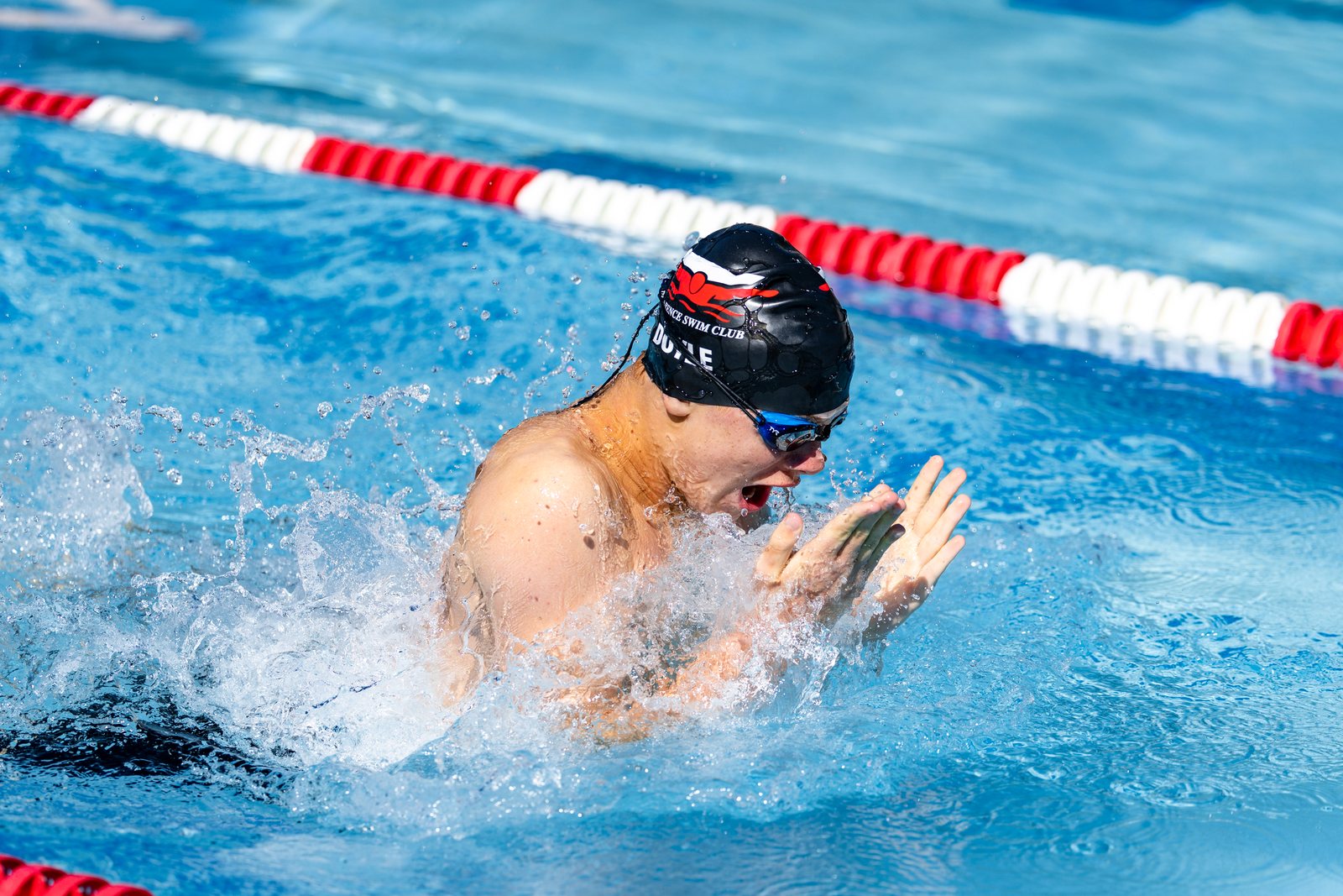 Butterfly swimmer surging out of the water mid-stroke