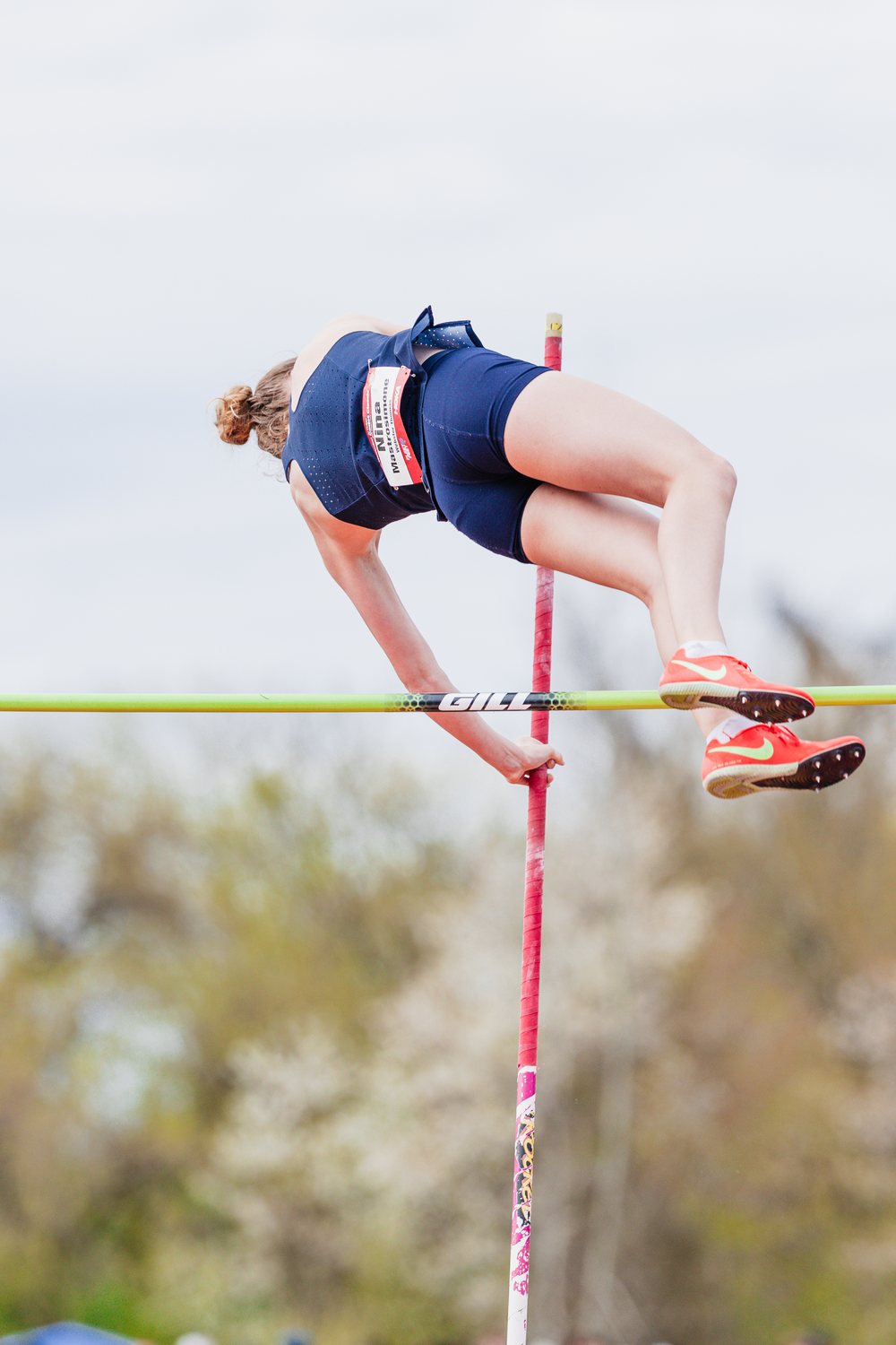 Pole vaulter arching over the bar against the sky