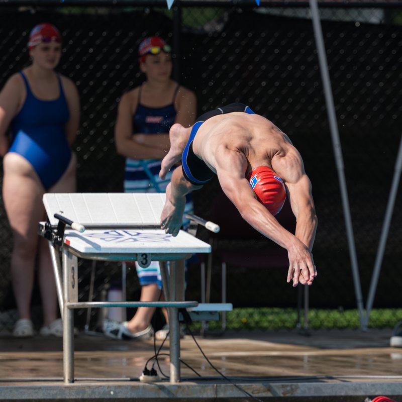 Swimmer launching off the starting block in a racing dive